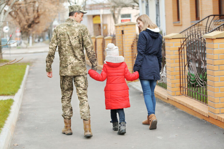 Happy soldier with family outdoors